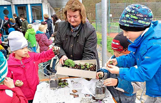 Auf dem Gelände des Raitenhaslacher Sportvereins bastelten die Kinder (im Bild mit Rosamunde Pfeiffer) hingebungsvoll an ihrem Mini-Gewächshaus. − Foto: Iris Jerschow