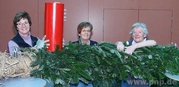 Christa Gassenmeyer, Else Rapp und Inge Eckl banden gestern den Riesen-Adventskranz für die Eingangshalle des Bürgerzentrums aus einem hohen Stapel Tannenzweige zusammen. − Fotos: Gerlitz