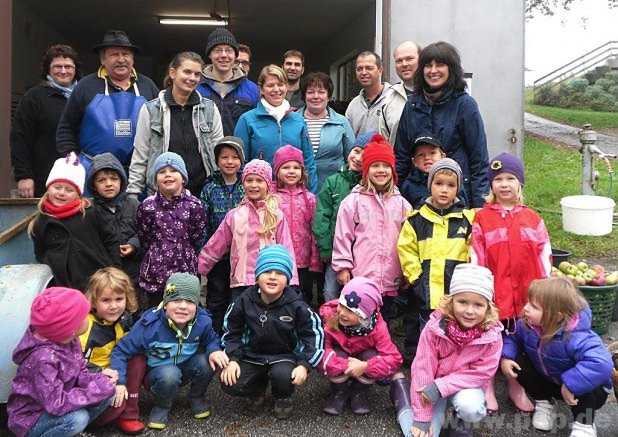 Zusammen mit einigen Eltern freuen sich die Kinder ber den Apfelsaft, den die Mitglieder des Gartenbauvereins Brigitte Salzinger und Willi Stolz (hinten von links), sowie Anna Engelsperger und Franz Riedelsheimer (hinten 4. und 5. von rechts) aus den gespendeten pfel gepresst hatten.  − Foto: Eichinger